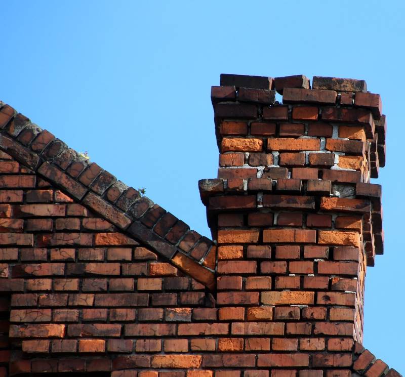 Damaged chimney on an Bolton home showing cracks and missing mortar